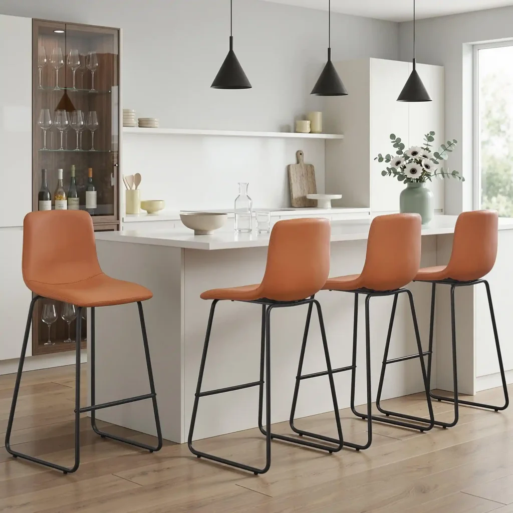 Modern white kitchen island with four tan faux leather counter stools featuring black metal frames and integrated footrests.
